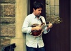 compose and perform an original composition on the mandolin or guitar
