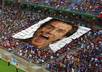 create a photo of a hundert of people holding your message or photo on a great football stadium
